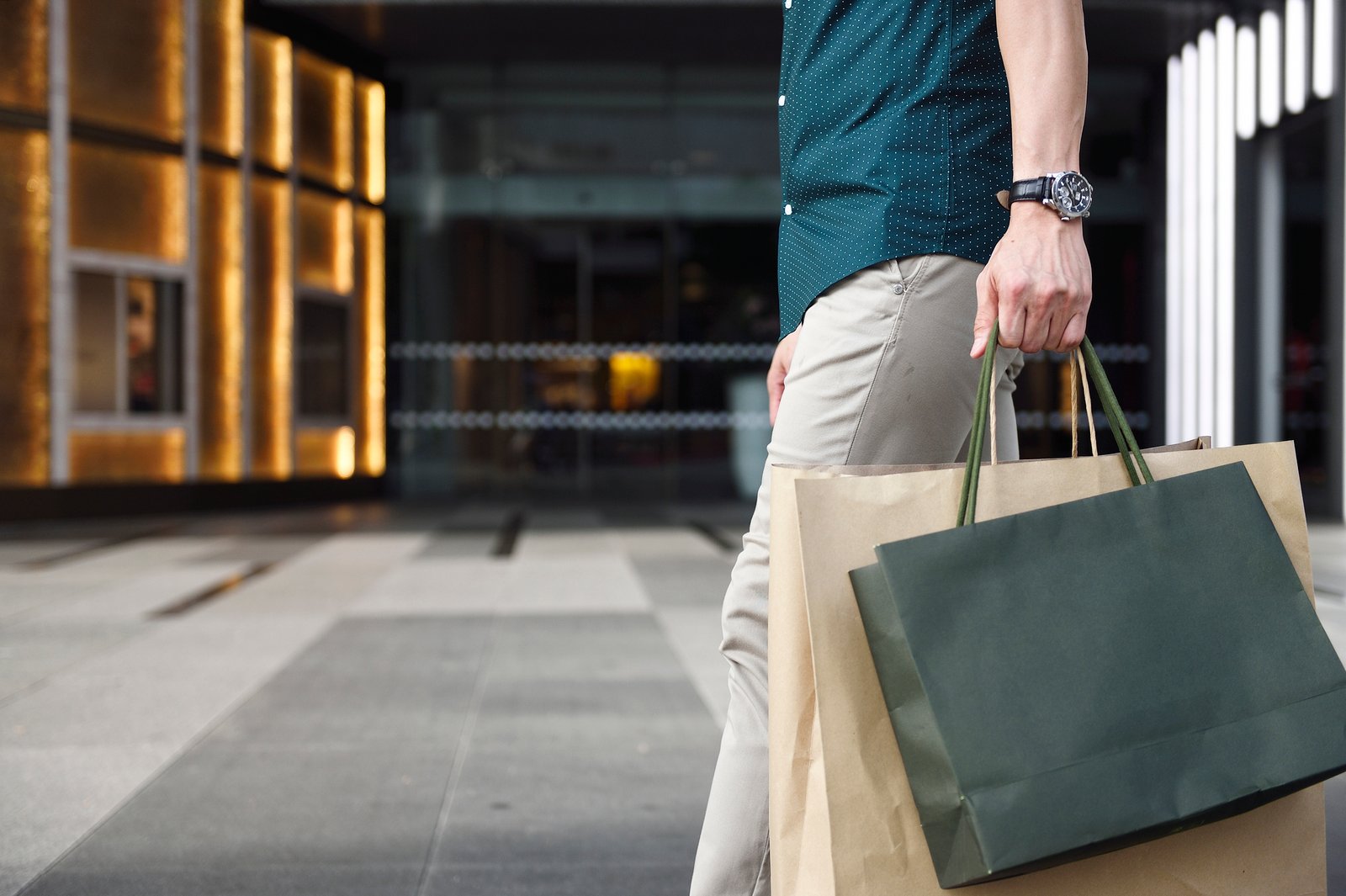 Man's legs and shopping bags outside a luxury mall